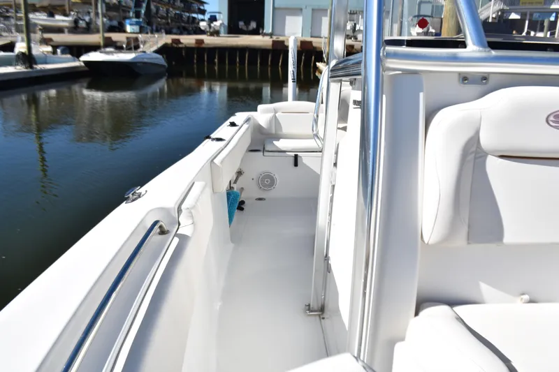 Slide: The Image of 2018 Sea Hunt Ultra 225 boat interior with white seating, docked at marina. - 18