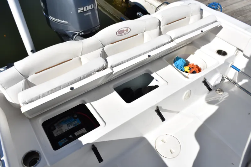 Slide: The Image of 2018 Sea Hunt Ultra 225 boat interior with storage compartments and Yamaha 200 engine. - 28