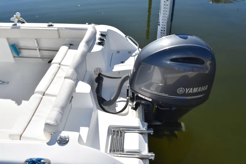 Slide: The Image of 2018 Sea Hunt Ultra 225 boat with Yamaha outboard motor, docked on calm water. - 31