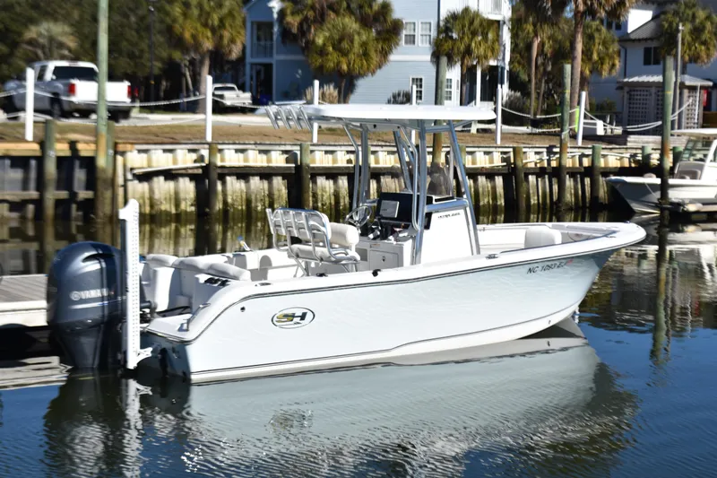 Slide: The Image of 2018 Sea Hunt Ultra 225 boat docked in a marina, featuring a Yamaha outboard motor. - 6