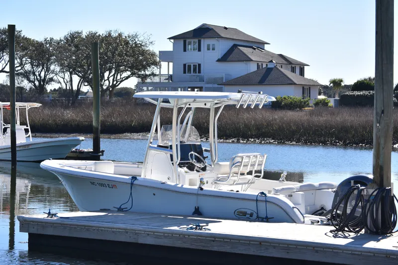 Slide: The Image of 2018 Sea Hunt Ultra 225 boat docked near waterfront home. - 8