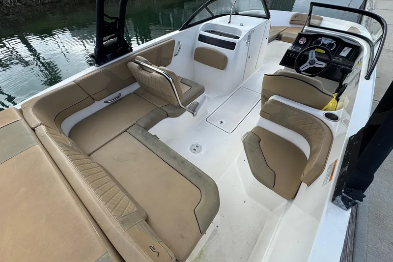 Slide: The Image of 2022 Bayliner VR6 Bowrider OB interior with tan seating and steering console. - 13