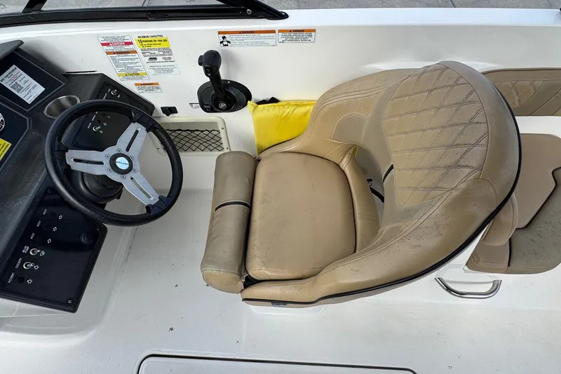 Slide: The Image of 2022 Bayliner VR6 Bowrider OB cockpit with steering wheel and beige captain's seat. - 21