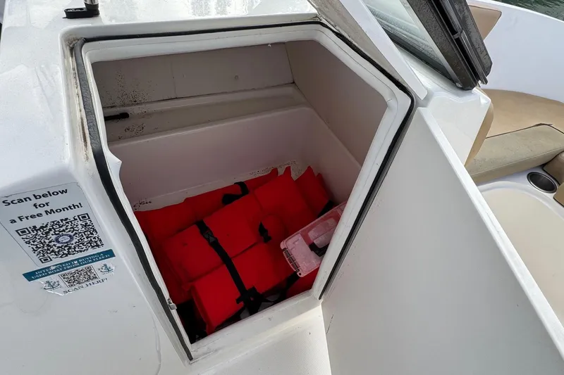 Slide: The Image of Storage compartment on 2022 Bayliner VR6 Bowrider OB with life jackets and QR code. - 30