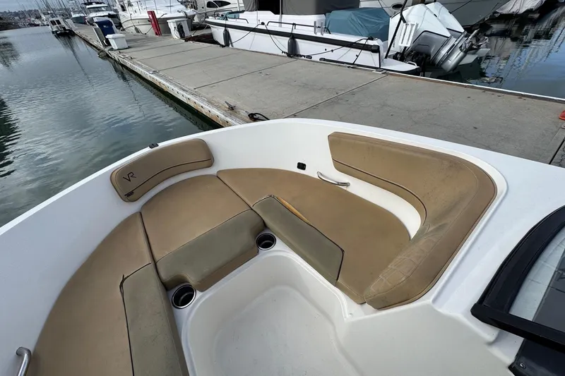 Slide: The Image of 2022 Bayliner VR6 Bowrider OB boat interior with tan seating at marina dock. - 33