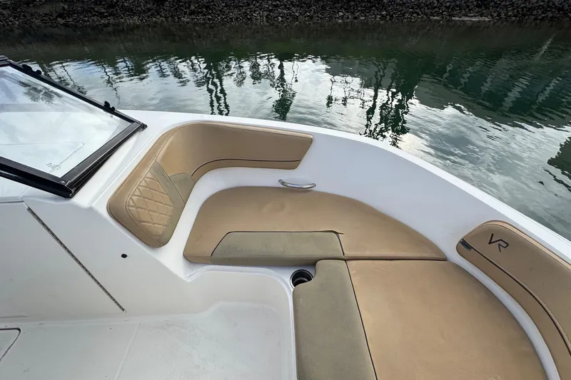 Slide: The Image of 2022 Bayliner VR6 Bowrider OB interior with tan seating by water. - 35