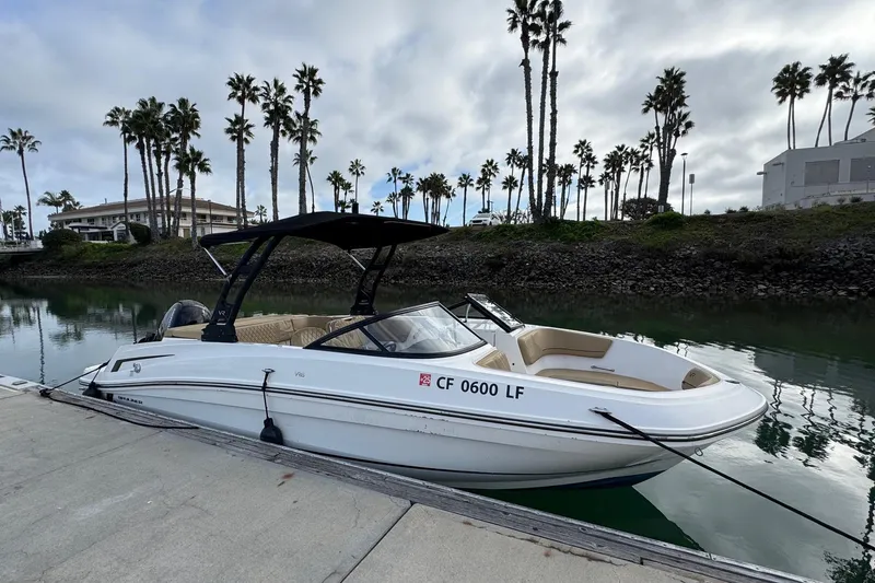 Slide: The Image of 2022 Bayliner VR6 Bowrider OB docked by palm trees, calm water reflection. - 6