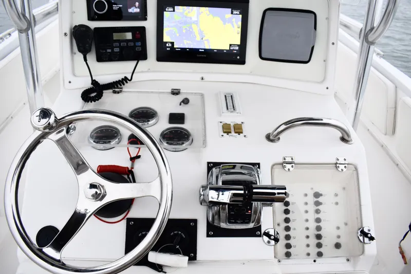 Slide: The Image of 2001 Fountain 31 Tournament Edition boat dashboard with steering wheel and navigation controls. - 21