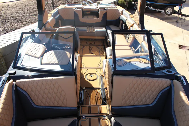 Slide: The Image of 2026 Tigé 24RZX boat interior with luxurious tan and black seating, open windshield. - 21