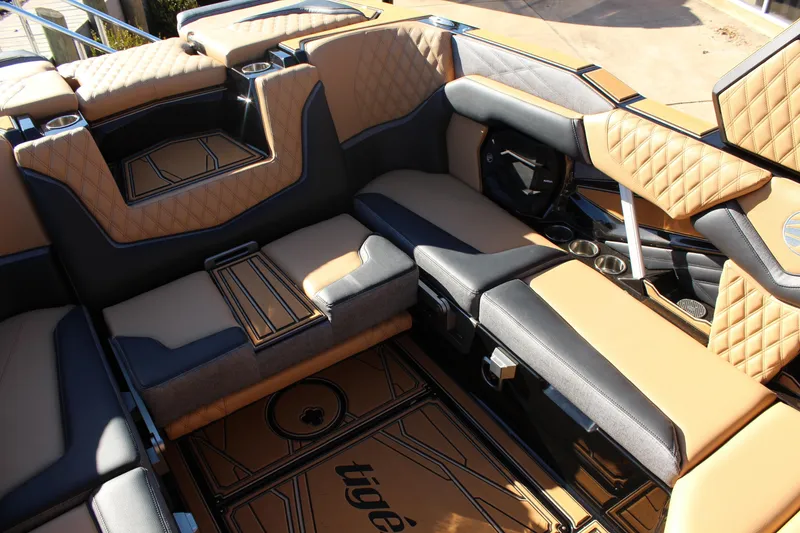 Slide: The Image of Luxurious interior of 2026 Tigé 24RZX boat with tan and black seating. - 23
