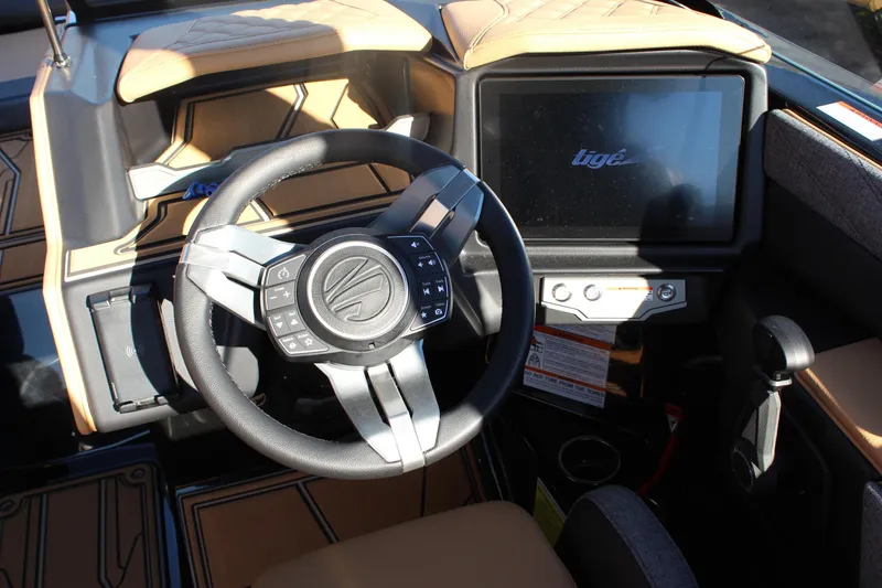 Slide: The Image of 2026 Tigé 24RZX boat dashboard with steering wheel and touchscreen display. - 24
