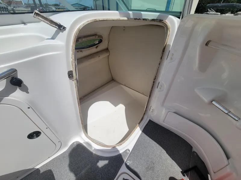 Slide: The Image of 2007 Chaparral Sunesta 214 boat storage compartment with open door, white interior. - 17