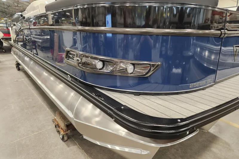 Slide: The Image of 2026 Tahoe Pontoon 25 Cascade Quad Lounge, Platinum Edition, in a showroom setting. - 32