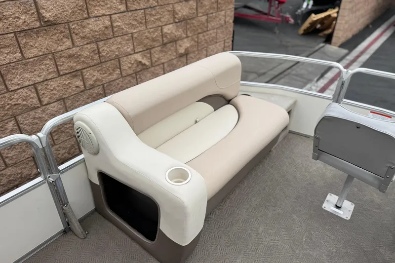 Slide: The Image of 2004 Sun Tracker Party Barge 21 interior with beige seating and cup holder. - 10