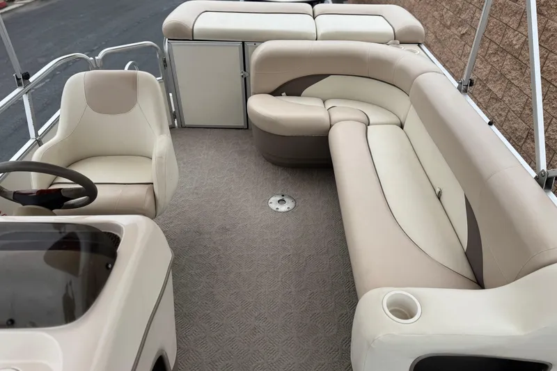 Slide: The Image of 2004 Sun Tracker Party Barge 21 interior with beige seating and steering console. - 15