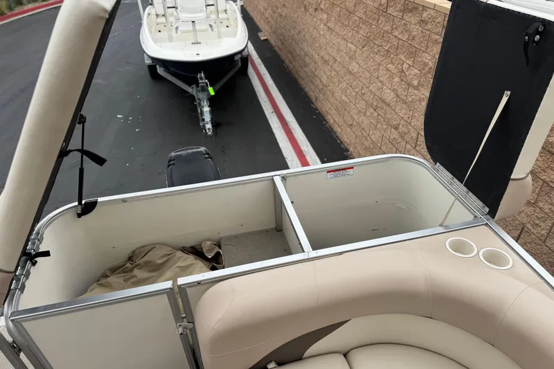 Slide: The Image of 2004 Sun Tracker Party Barge 21 interior with open storage compartments and cup holders. - 17