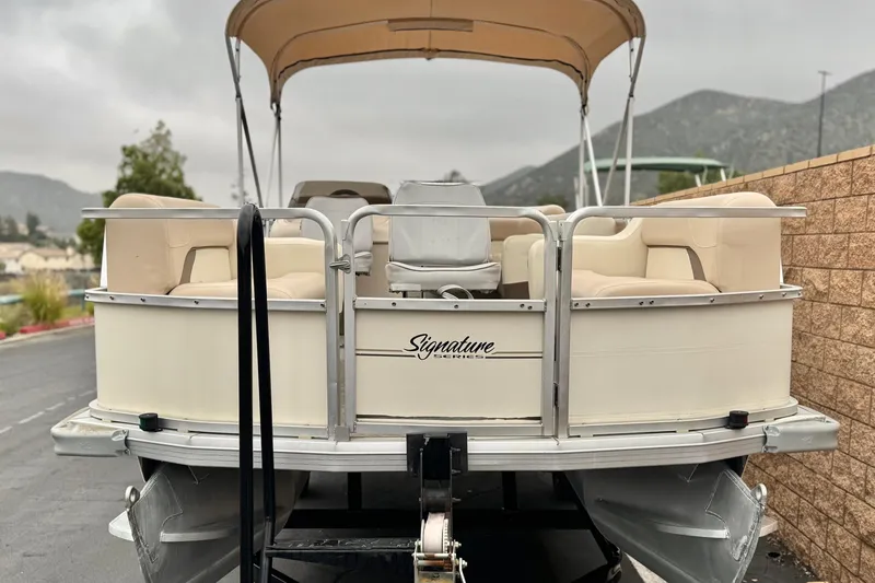 Slide: The Image of 2004 Sun Tracker Party Barge 21 pontoon boat with beige seating and canopy. - 2