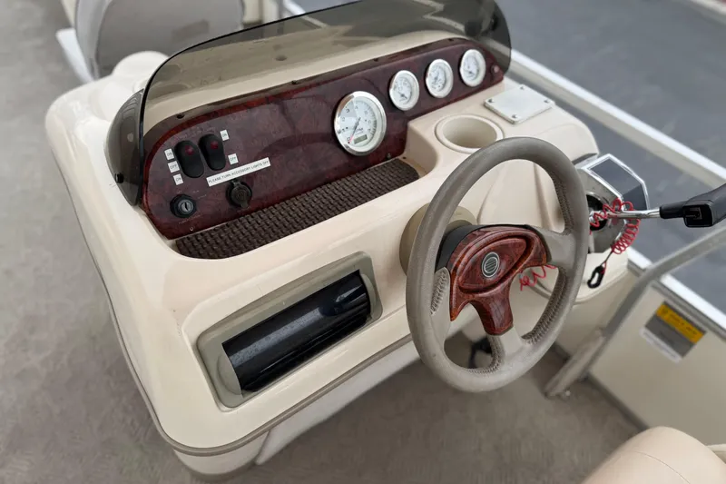 Slide: The Image of 2004 Sun Tracker Party Barge 21 dashboard with steering wheel and control panel. - 21