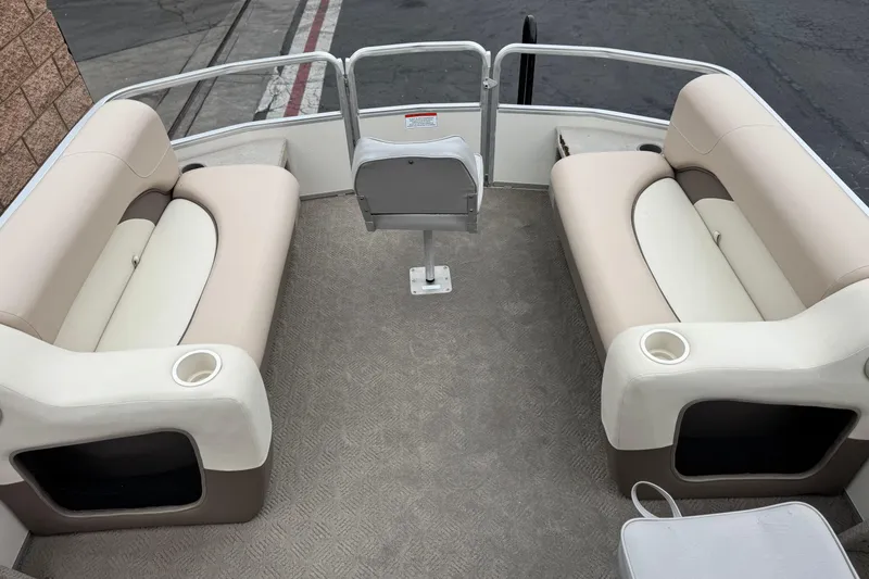 Slide: The Image of 2004 Sun Tracker Party Barge 21 interior with beige seating and cup holders. - 9