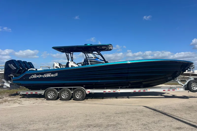 Slide: The Image of 2026 Nor-Tech 390 Sport Center Console boat on trailer under clear blue sky. - 3