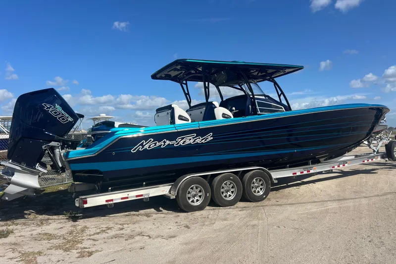 Slide: The Image of 2026 Nor-Tech 390 Sport Center Console boat on trailer, blue and black design. - 4