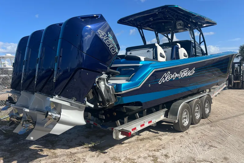 Slide: The Image of 2026 Nor-Tech 390 Sport Center Console boat with triple outboard engines on a trailer. - 5