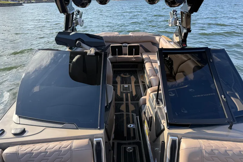 Slide: The Image of 2025 Centurion Ri245 boat interior with luxurious seating and sleek design on a lake. - 14
