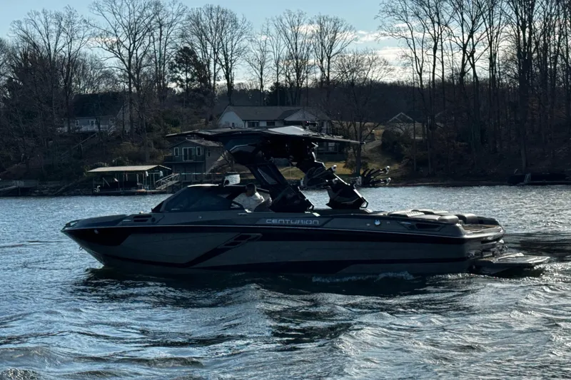 Slide: The Image of 2025 Centurion Ri245 boat cruising on a lake with wooded shoreline background. - 3
