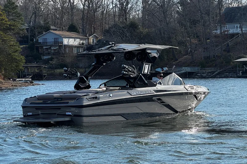 Slide: The Image of 2025 Centurion Ri245 boat cruising on a lake near wooded shoreline. - 7