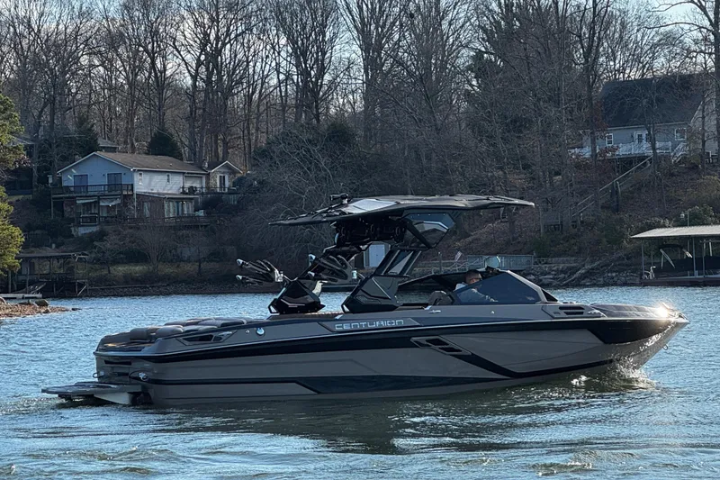 Slide: The Image of 2025 Centurion Ri245 boat cruising on a lake with wooded shoreline. - 8