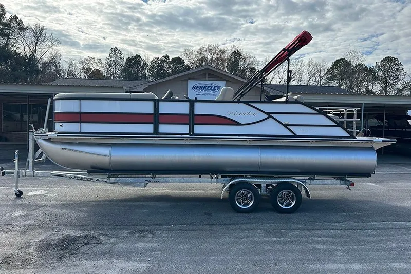 Slide: The Image of 2026 Bentley Pontoons Legacy 223 Swingback on trailer, parked outdoors under cloudy sky. - 5