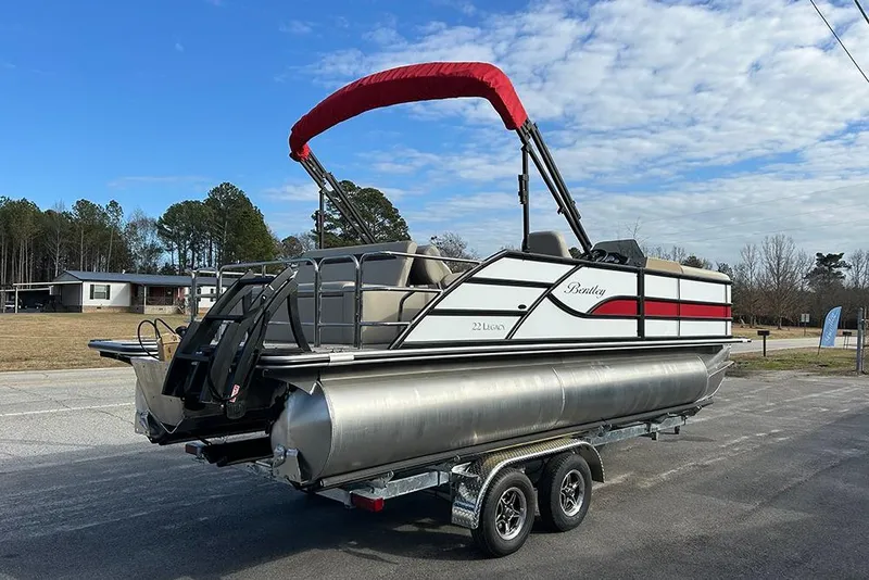 Slide: The Image of 2026 Bentley Pontoons Legacy 223 Swingback on trailer, featuring sleek design and red canopy. - 8