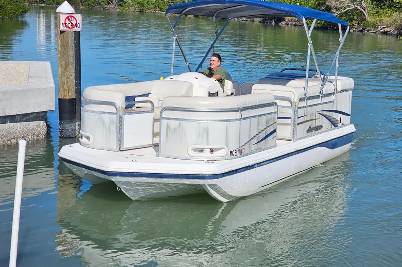 Slide: The Image of 2005 Hurricane FunDeck 218 RE OB pontoon boat on calm water, no mooring sign visible. - 1