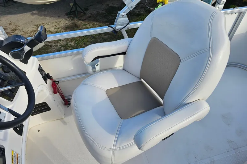 Slide: The Image of Captain's chair on 2005 Hurricane FunDeck 218 RE OB boat, featuring steering controls. - 18