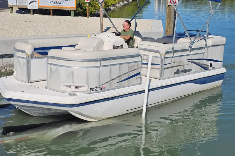 Slide: The Image of 2005 Hurricane FunDeck 218 RE OB pontoon boat on calm water. - 2