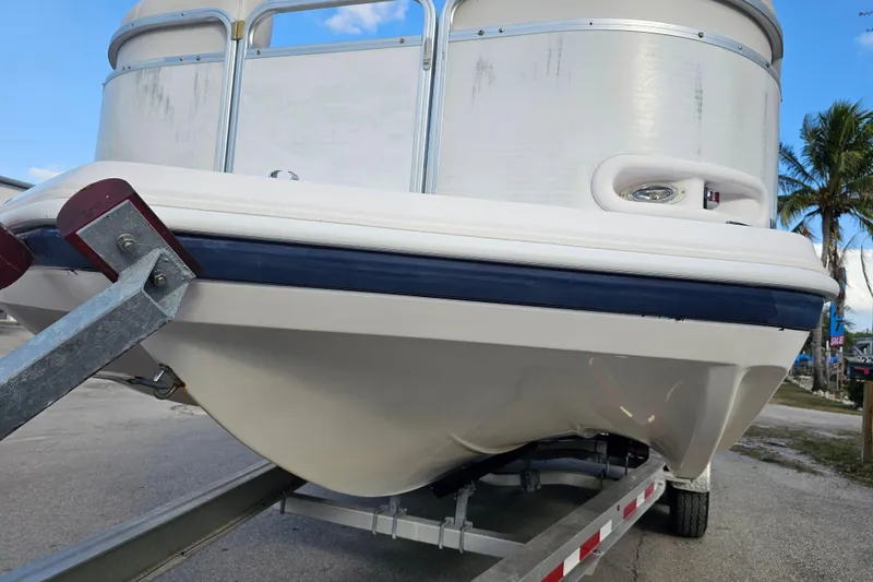 Slide: The Image of 2005 Hurricane FunDeck 218 RE OB boat on trailer, palm trees in background. - 7