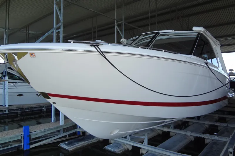 Slide: The Image of 2022 Regal LS36 boat in a covered dock, showcasing sleek design and white exterior. - 1