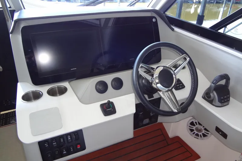 Slide: The Image of 2022 Regal LS36 boat helm with dual screens, steering wheel, and control panel. - 15