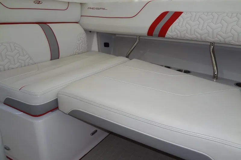Slide: The Image of 2022 Regal LS36 boat interior with white and red cushioned seating. - 22