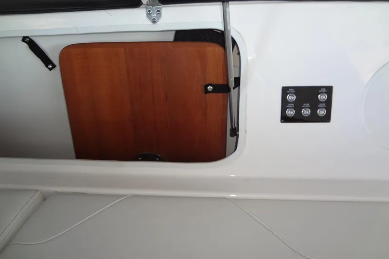 Slide: The Image of 2022 Regal LS36 boat interior with wooden panel and control switches. - 33
