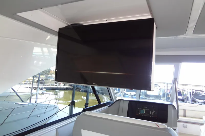 Slide: The Image of 2022 Regal LS36 boat interior with mounted TV and marina view. - 34