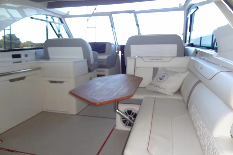Slide: The Image of 2022 Regal LS36 boat interior with plush seating and wooden table. - 5