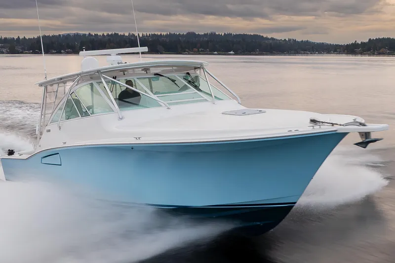 Slide: The Image of 2006 Cabo 40 Express boat cruising on a calm lake under cloudy skies. - 10