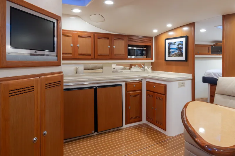 Slide: The Image of Luxurious 2006 Cabo 40 Express yacht interior with wood cabinetry and modern amenities. - 14