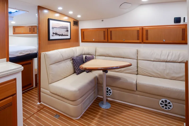 Slide: The Image of Luxurious 2006 Cabo 40 Express yacht interior with cozy seating and elegant wood finishes. - 16
