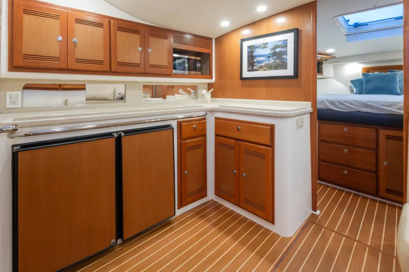 Slide: The Image of Luxurious 2006 Cabo 40 Express yacht interior with wood cabinetry and modern amenities. - 17