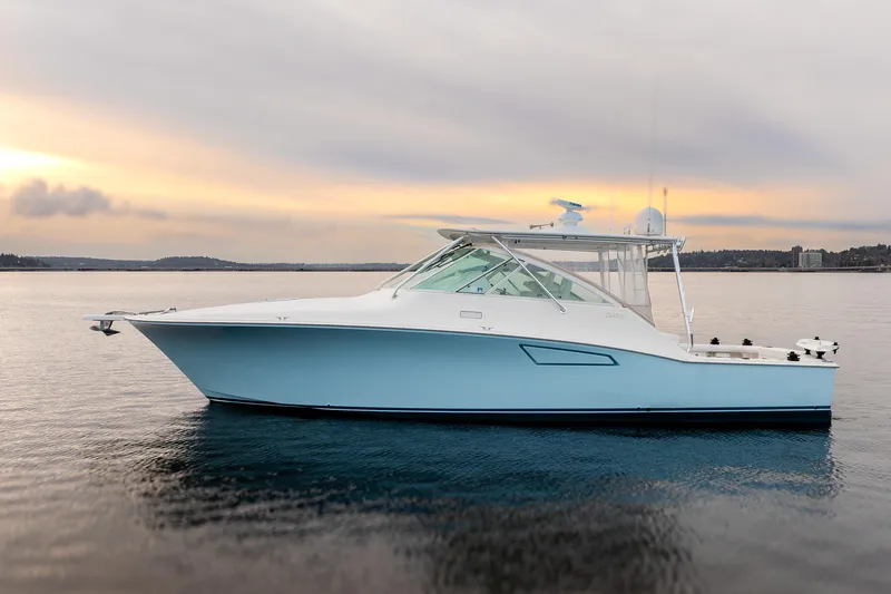 Slide: The Image of 2006 Cabo 40 Express boat on calm water at sunset. - 2