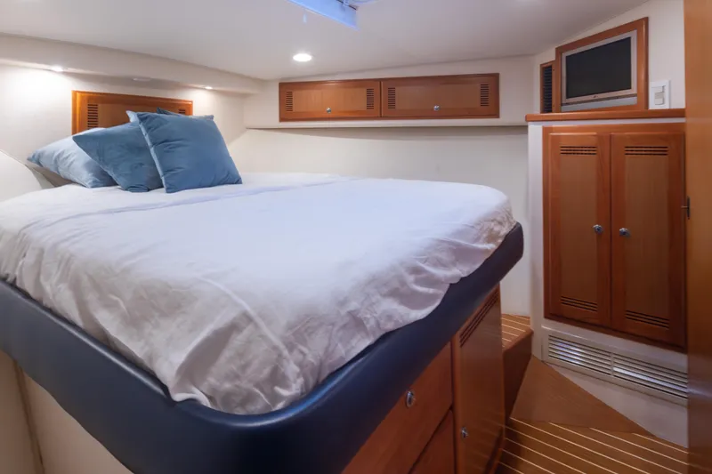 Slide: The Image of Luxurious cabin interior of 2006 Cabo 40 Express yacht with cozy bedding and wooden cabinetry. - 24