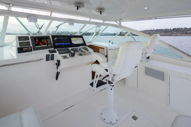 Slide: The Image of Helm of 2006 Cabo 40 Express yacht with navigation equipment and white captain's chairs. - 29
