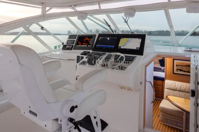 Slide: The Image of 2006 Cabo 40 Express yacht helm with navigation screens and cabin view. - 34